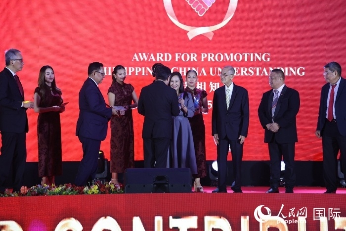 黃溪連大使給榮獲“重要貢獻獎”的奎松市市長喬伊·貝蒙蒂等人頒獎。人民網(wǎng)記者 樊帆攝