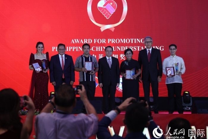 黃溪連大使和菲中了解協(xié)會主席與榮獲“友誼獎”的獲獎者合影留念。人民網(wǎng)記者 樊帆攝